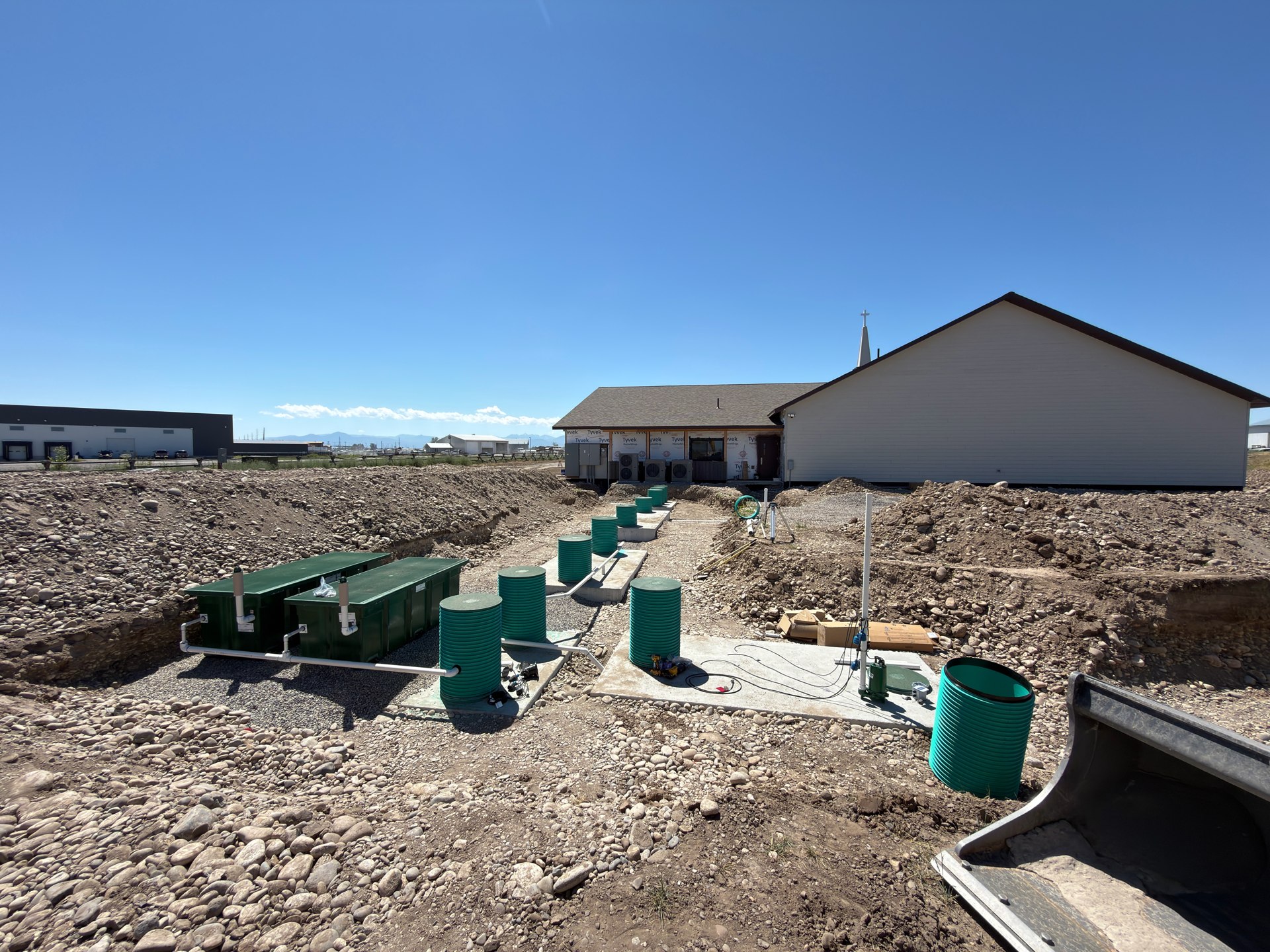 Septic system installation with tanks, green risers, and treatment equipment in place